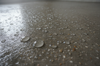 HAZME UNA IMAGEN DE UN SUELO HUMEDO CON UN LIQUIDO IMPERMEABILIZANTE APLICADO